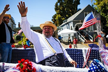 A man waves to the crowd as he rides a float during the 4th of July Parade in Alameda, California on Monday, July 4, 2016. / AFP / GABRIELLE LURIE (Photo credit should read GABRIELLE LURIE/AFP/Getty Images)