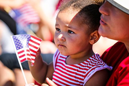 Athena Volante, 2, holds an American flag as she sits with her grandmother, Valla Burnett (R), during the 4th of July Parade in Alameda, California on Monday, July 4, 2016. / AFP / GABRIELLE LURIE (Photo credit should read GABRIELLE LURIE/AFP/Getty Images)