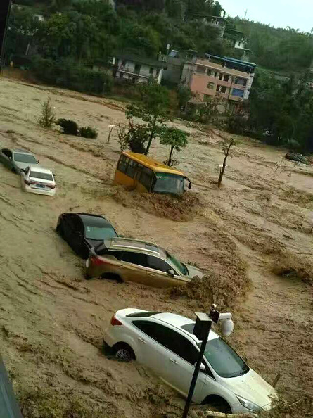 This image taken with a cameraphone shows cars and buses being washed away by floodwaters in Fuzhou, in eastern China's Fujian province on July 9, 2016. A tropical storm made landfall in China on July 9, the country's national meteorological center said, a day after Super Typhoon Nepartak lashed Taiwan with powerful winds and torrential rain. / AFP / STR / China OUT (Photo credit should read STR/AFP/Getty Images)