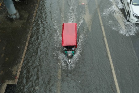 7月20日北京暴雨。图为一辆三轮车在积水中艰难前行。 (STR/AFP/Getty Images)