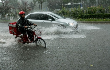 7月20日北京街头，暴雨中的摩托车和汽车。(STR/AFP/Getty Images)