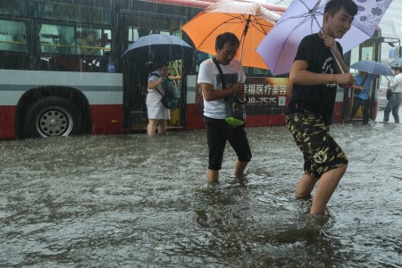7月20日北京暴雨。图为北京路上行人。(STR/AFP/Getty Images)