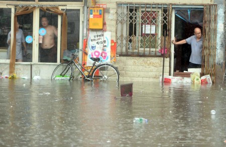 7月20日，北京居民看着屋外的洪水。(STR/AFP/Getty Images)