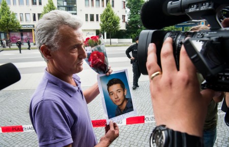 7月23日，一位受难者的父亲捧着儿子的照片。( Joerg Koch/Getty Images)