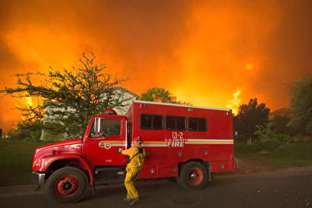 消防队员在受砂火威胁的民宅前。（DAVID MCNEW/AFP/Getty Images）