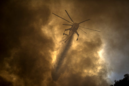 7月24日聖塔克拉瑞塔沙火（Sand Fire）現場，一架滅火直升飛機在灑水。（David McNew/Getty Images）