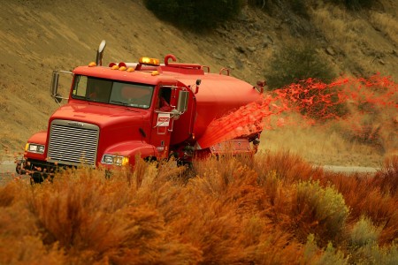加州洛杉矶圣克拉里塔（Santa Clarita）发生大火，洛杉矶当局派出飞机抛洒阻燃粉，天地都弥漫着橙粉色的物质。 (David McNew/Getty Images)