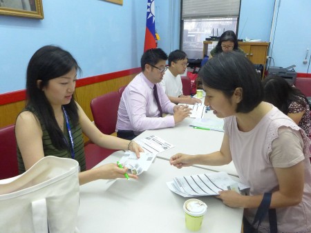 邝女士（右）在记者会后就填表参加筛检。
