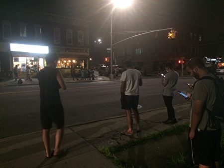 12日晚近10點，一群年輕人在皇后區艾姆赫斯特（Elmhurst）街道旁，仍在忙著用手機「抓精靈」。
