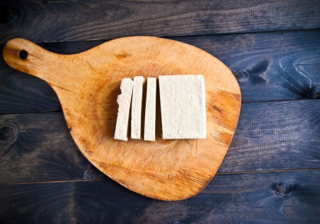 Slices of raw tofu on shabby cutting board(shutterstock)