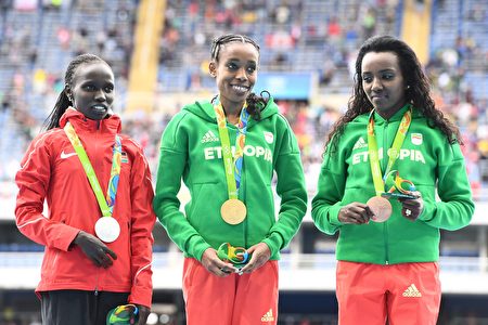Silver medallist Kenya's Vivian Jepkemoi Cheruiyot (L), Gold medallist Ethiopia's Almaz Ayana (C), and Bronze medallist Ethiopia's Tirunesh Dibaba pose for photos on the podium afer the medal ceremony for Women's 10,000m athletics event at the Rio 2016 Olympic Games at the Olympic Stadium in Rio de Janeiro on August 12, 2016. / AFP / Jewel SAMAD (Photo credit should read JEWEL SAMAD/AFP/Getty Images)