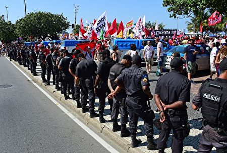 Riot police line next to a demonstration of residents of Rio de Janeiro against interim president Michel Temer, political upheaval, corruption and the cost of the Rio 2016 Olympics Games, in front of the Copacabana Palace Hotel on August 5, 2016. Thousands of Brazilians angry at political upheaval, corruption and the cost of the Rio Olympics blocked traffic in protests hours before the gala opening ceremony. Most people came to vent anger at center-right interim president Michel Temer who took power in May on the suspension of the elected leftist president, Dilma Rousseff, for an impeachment trial that her supporters claim amounts to a coup. / AFP / TASSO MARCELO (Photo credit should read TASSO MARCELO/AFP/Getty Images)