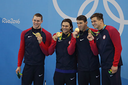 里约奥运第八天，（右起）倪家骏（Nathan Adrian）和队友菲尔普斯（Michael Phelps）、米勒（Cody Miller）和墨菲（Ryan Murphy）站在男子4×100米混合泳接力决赛冠军领奖台上。（Rob Carr/Getty Images）