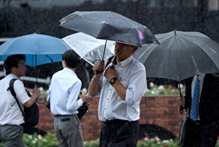 日本受到颱風襲擊，圖為民眾在狂風暴雨中前行。(TORU YAMANAKA/AFP/Getty Images)
