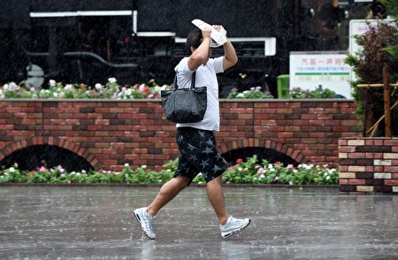 日本受到颱風襲擊，圖為民眾在狂風暴雨中前行。(TORU YAMANAKA/AFP/Getty Images)