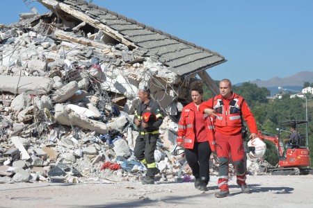 意大利中部24日发生里氏6.2强震，导致多座古城小镇严重受损。图为重灾区阿马特里切镇，在现场搜救的原救难人员。 (ANDREAS SOLARO/AFP/Getty Images)
