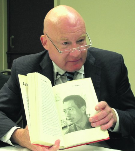 8月16日，葛特曼在紐西蘭惠靈頓接受大紀元專訪。圖為他向記者展示他的著作《大屠殺》。（視頻截圖／大紀元）