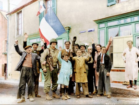  1944年6月12日，法國聖奧諾裡訥鎮的民眾在三色旗下歡迎三名盟軍（美國）大兵。(Courtesy of Marina Amaral)