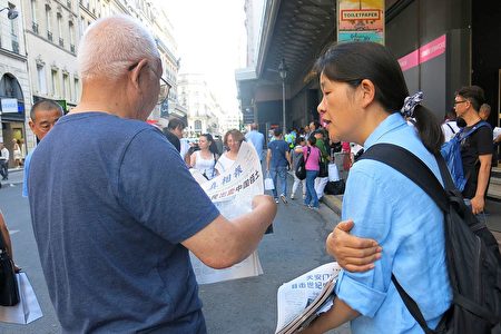 法轮功学员在向巴黎拉法耶特商店门前的大陆游客讲真相。（明慧网）