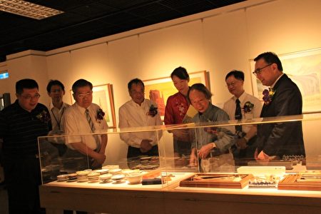 研究台湾美术学者李钦贤(右三)领着贵宾欣赏郭雪湖画展。（谢月琴／大纪元）