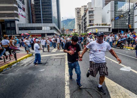 An injured demonstrator (L) is take away after clashes between riot police and opposition activists marching in Caracas, on September 1, 2016. Venezuela's opposition and government head into a crucial test of strength Thursday with massive marches for and against a referendum to recall President Nicolas Maduro that have raised fears of a violent confrontation. / AFP / JUAN BARRETO (Photo credit should read JUAN BARRETO/AFP/Getty Images)