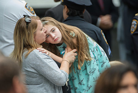 Family members embrace during the 15th Anniversary of September 11 at the 9/11 Memorial and Museum, on September 11, 2016 in New York. The United States on Sunday commemorated the 15th anniversary of the 9/11 attacks. / AFP / Bryan R. Smith (Photo credit should read BRYAN R. SMITH/AFP/Getty Images)