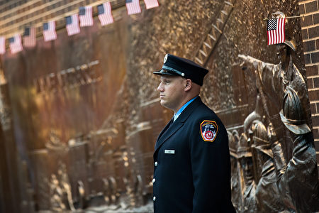 NEW YORK, NY - SEPTEMBER 11: A New York City firefighter stands outside FDNY Engine 10, Ladder 10 station near the September 11 Memorial site and One World Trade Center, September 11, 2016 in New York City. Throughout the country services are being held to remember the 2,977 people who were killed in New York, the Pentagon and in a field in rural Pennsylvania. (Photo by Drew Angerer/Getty Images)