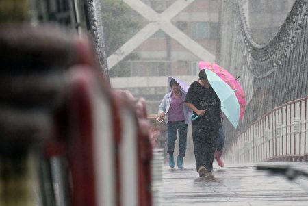 Local residents walk on a suspension bridge in Bitan in the New Taipei City, as Typhoon Megi approaching the east Taiwan on September 27, 2016. Typhoon Megi churns towards Taiwan with powerful winds and rains in the third typhoon to hit the island in two weeks. / AFP / SAM YEH (Photo credit should read SAM YEH/AFP/Getty Images)