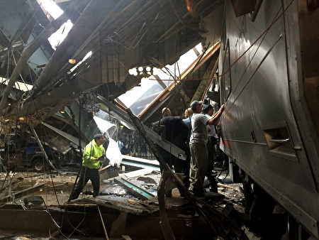 事故现场一片狼藉，救援人员正在搜救受困乘客。(Pancho Bernasconi/Getty Images)
