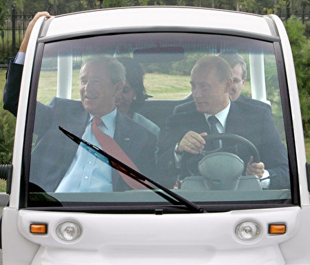 2006年7月15日，普京在聖彼得堡駕駛一輛高爾夫球車，載布什。(DMITRI ASTAKHOV/AFP/Getty Images)