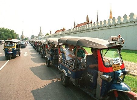 在路旁等候乘客的嘟嘟车。（Photo by PORNCHAI KITTIWONGSAKUL / AFP）