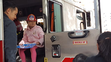 顾雅明举办秋季园游会，孩子戴上消防局赠送的消防员头盔，到消防车上参观。