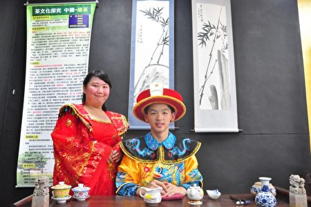 中国绿茶的茶席，穿着龙袍的男学生扮成帅气皇帝和贵妃微笑着，模样煞是可爱。（赖月贵／大纪元）