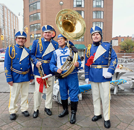 11月20日，参加多伦多圣诞游行的乌克兰乐团成员与天国乐团成员（右二）合照。乌克兰乐团成员Mykola Zakalinzhnyi（左一）表示，天国乐团非常棒、阵容强大。（周月谛／大纪元）