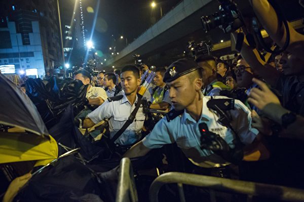 Police use pepper spray to stop protesters charging outside the Chinese Liason Office in Hong Kong on November 6, 2016, during a protest against an expected interpretation of the city's constitution -- the Basic Law -- by China's National People's Congress Standing Committee (NPCSC) over the invalid oath-taking attempts by newly elected lawmakers Baggio Leung and Yau Wai-ching at the Legislative Council last month. Thousands took to Hong Kong's streets on November 6 after Beijing said it would step into an escalating row over whether two city lawmakers who advocate a split from China should be banned from taking up their seats. / AFP / ISAAC LAWRENCE (Photo credit should read ISAAC LAWRENCE/AFP/Getty Images)