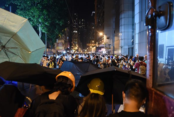Police stand beyond a line of protesters (foreground) as they block off a street amid ongoing protests in Hong Kong on November 6, 2016. Hong Kong police used pepper spray November 6 to drive back hundreds of protesters angry at China's decision to intervene in a row over whether two pro-independence lawmakers should be barred from the city's legislature. In chaotic scenes reminiscent of mass pro-democracy protests in 2014, demonstrators charged metal fences set up by police outside China's liaison office in the semi-autonomous city. / AFP / Anthony WALLACE (Photo credit should read ANTHONY WALLACE/AFP/Getty Images)
