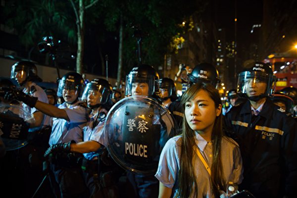 Yau Wai-ching (R) of the Youngspirations organisation, stands in front of riot police amid ongoing protests in Hong Kong on November 6, 2016. Hong Kong police used pepper spray November 6 to drive back hundreds of protesters angry at China's decision to intervene in a row over whether two pro-independence lawmakers should be barred from the city's legislature. In chaotic scenes reminiscent of mass pro-democracy protests in 2014, demonstrators charged metal fences set up by police outside China's liaison office in the semi-autonomous city. / AFP / ISAAC LAWRENCE (Photo credit should read ISAAC LAWRENCE/AFP/Getty Images)