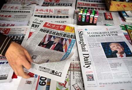 A man sorts Chinese newspapers featuring Donald Trump's victory in the US presidential elections on their front pages in Shanghai on November 10, 2016. The American public on November 9 voted for the Republican candidate Donald Trump to be the 45th President of the United States. / AFP / JOHANNES EISELE (Photo credit should read JOHANNES EISELE/AFP/Getty Images)