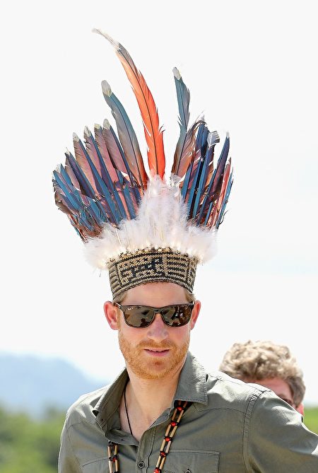 哈里王子代表女王对加勒比海地区进行访问。圭亚那偏远地区一位印第安村长送给这位远方贵客一件礼物——插着各种颜色羽毛的帽子。今年是圭亚那脱离英国获得独立50周年。 (Photo by Chris Jackson/Getty Images)