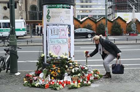 在遭受卡車恐襲的柏林聖誕市場的入口處，柏林市民在次日點燃蠟燭，獻上鮮花，以表悼念。（Sean Gallup／Getty Images）