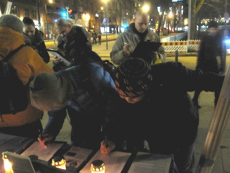 12月10日下午，芬蘭部分法輪功學員在首都市區進行燭光守夜，悼念被迫害致死的法輪功學員。民眾踴躍前來簽名，反對迫害。（李樂/大紀元）
