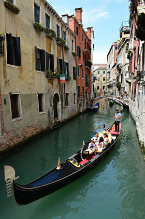 有着低调华丽的黑色船身，船夫站在船尾滑动并高声歌唱，这就是威尼斯独有且别具代表性的贡多拉。(OLIVIER MORIN / AFP)