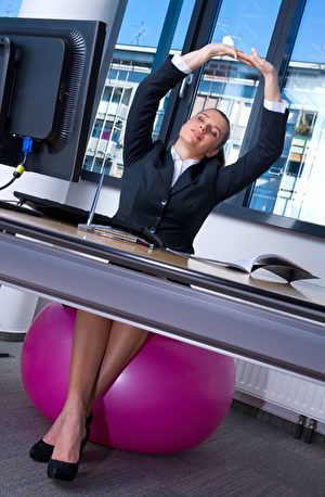 坐在锻练球上，脊椎用力做三维的转动。(dean bertoncelj/Shutterstock)