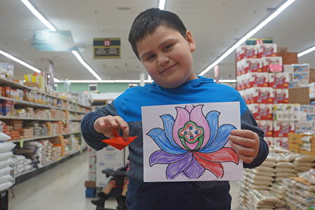 来自南美洲的男孩Anderson展示自己折叠的纸鹤和绘制的莲花。（林乐予／大纪元）