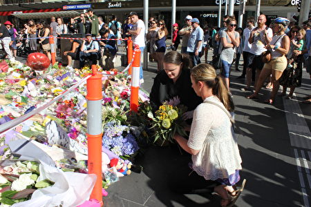 1月22日周日墨尔本市中心撞人案事发现场，不断有民众献上鲜花和玩具表示哀悼。图为Carrie Gregson（左）和Kelly Cross。（Lucy Liu/大纪元）