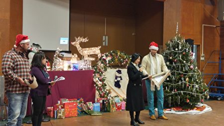 图：白石镇台湾同乡会圣诞晚会，两位德国人在介绍德国圣诞习俗。（邱晨/大纪元）