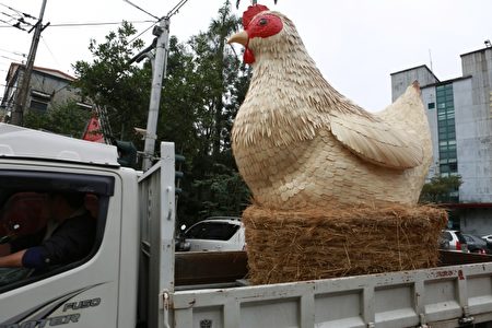 小貨車載送母雞模型踩街進花田。（曾漢東／大紀元）
