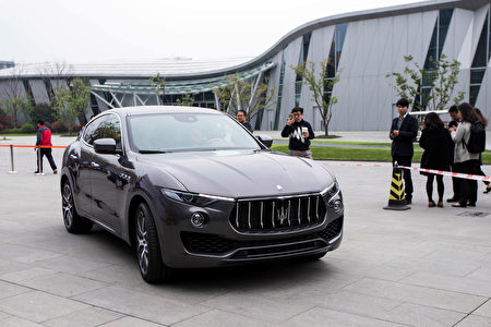 This photo taken on March 23, 2016 shows people taking photos of a Maserati Levante sport-utility vehicle in Hangzhou, eastern China's Zhejiang province. Chinese drivers are rushing to buy sport-utility vehicles in an "arms race" for safety on the country's hair-raising roads, analysts say, as SUV sales hit the gas despite a slowing economy. / AFP / STR / China OUT / TO GO WITH AFP STORY CHINA-AUTO-SHOW-SUV,FOCUS BY BENJAMIN CARLSON (Photo credit should read STR/AFP/Getty Images)
