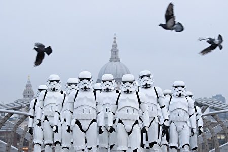 LONDON, ENGLAND - DECEMBER 15: People dressed as Stormtroopers from the Star Wars franchise of films pose on the Millennium Bridge to promote the latest release in the series, "Rogue One", on December 15, 2016 in London, England. "Rogue One: A Star Wars Story" is the first of three standalone spin-off films and is 外星人入侵地球了吗？圣诞节前，《星球大战》新一集《侠盗一号》（Rogue One）在英国上映，这是举行的新片造势活动。 (Photo by Leon Neal/Getty Images)