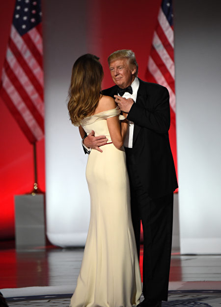 US President Donald Trump and First Lady Melania Trump take the stage at the Freedom Inaugural Ball, January 20, 2017, in Washington, DC. / AFP / Robyn Beck (Photo credit should read ROBYN BECK/AFP/Getty Images)